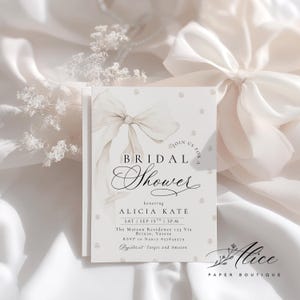 K&ouml;nnte beinhalten: Eine Einladung zur Brautparty in einer sanften, neutralen Farbpalette. Das Design zeigt eine Aquarellschleife und Perlenakzente. Der Text lautet "Bridal Shower" und enth&auml;lt Details f&uuml;r Alicias Brautparty.