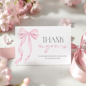 Puede incluir: Una tarjeta de agradecimiento rosa con un lazo de acuarela y el texto "THANK you & FOR SHOWERING OUR BABY WITH SO MUCH LOVE! ADD YOUR OWN TEXT HERE"
