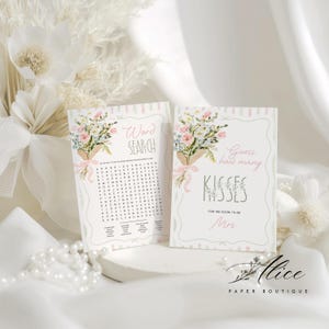May include: Two bridal shower game cards. One card says "Word Search" and the other says "Guess how many kisses". Both cards have a floral bouquet illustration with pink ribbons. The Alice Paper Boutique logo is in the bottom right.