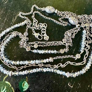 May include: A set of three ceramic nesting bowls in shades of blue, green, and white. The bowls feature a speckled glaze and a simple, modern design. The largest bowl measures approximately 6 inches in diameter.