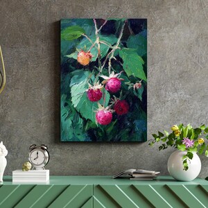 Op de afbeelding: Olieverfschilderij van een frambozentak met groene bladeren en rijpe rode bessen. Het kunstwerk wordt aan een muur getoond, met een groene kast en een witte vaas met bloemen op de voorgrond. Het schilderij heeft een getextureerde, impressionistische stijl.