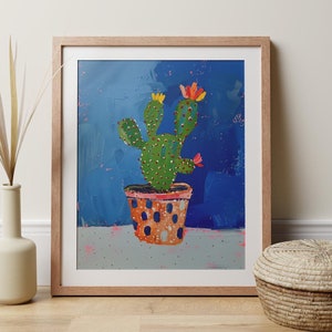 Può includere: Un dipinto di un cactus verde con fiori gialli e rossi in un vaso a pois su uno sfondo blu.