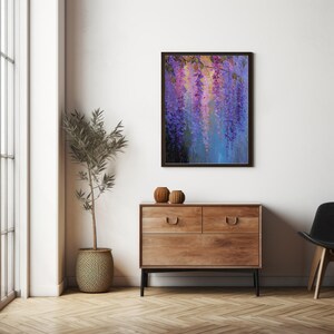May include: A framed painting of purple wisteria flowers hangs on a white wall. The artwork is above a wooden chest of drawers. A potted plant and two decorative vases sit on the chest. The room has wooden flooring.