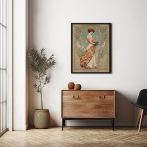 May include: A framed art print featuring a woman in a flowing dress, holding flowers. The artwork has a vintage style with a color palette of beige, brown, and teal. The print is displayed above a wooden dresser with two drawers.