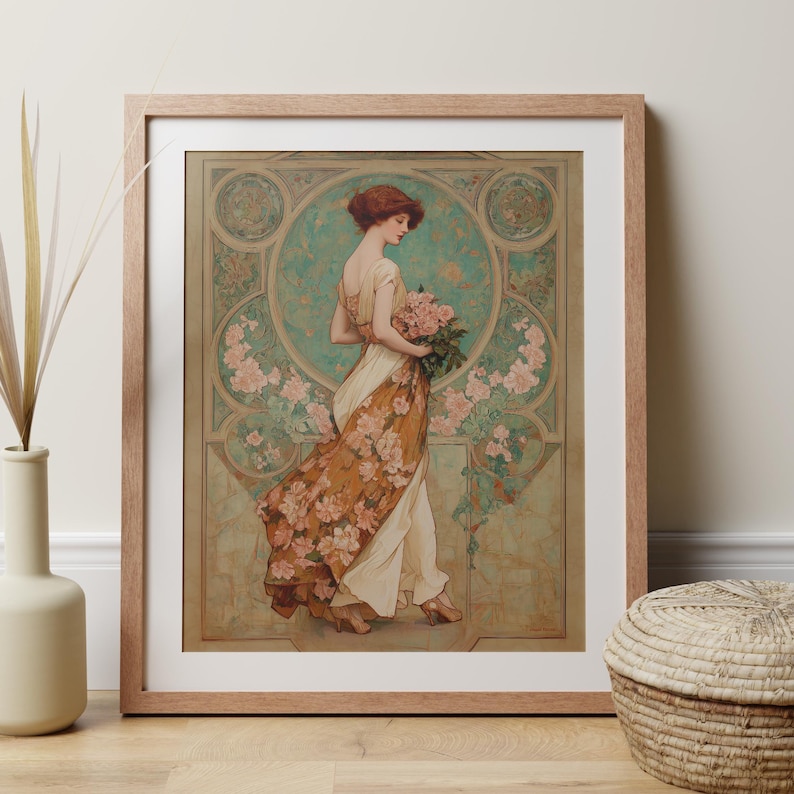 May include: Framed art print featuring a woman in a flowing dress, holding a bouquet of pink flowers. The artwork has a vintage style with floral and geometric patterns in shades of orange, green, and cream. The print is displayed in a light brown wooden frame.