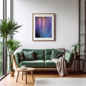 May include: A framed painting of purple and blue wisteria blossoms hangs above a green velvet sofa. The room features a wooden coffee table, a potted plant, and a neutral-coloured throw blanket. The decor creates a cosy and inviting atmosphere.