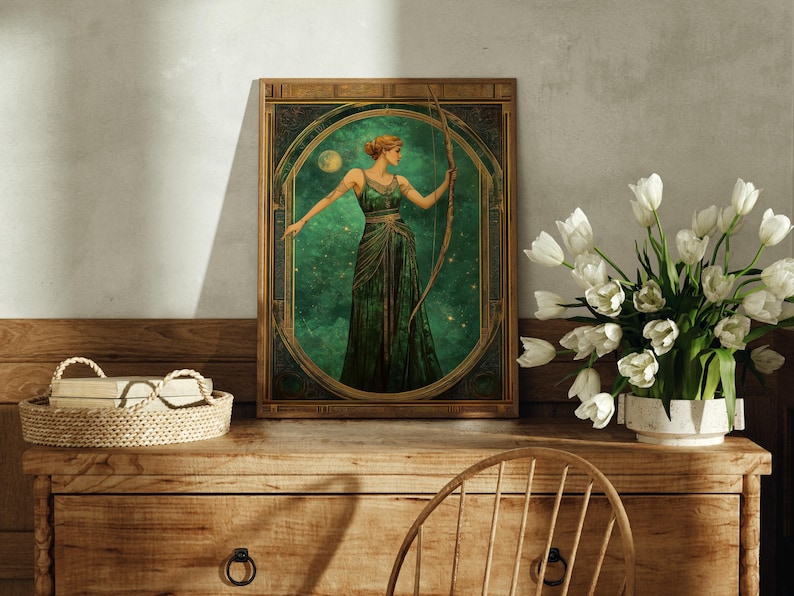 K&ouml;nnte beinhalten: Eine gerahmte Illustration einer Frau in einem gr&uuml;nen Kleid, die einen Bogen und Pfeil h&auml;lt. Der Hintergrund ist dunkelgr&uuml;n mit Sternen und einem Mond.