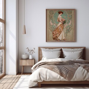 May include: A framed art print featuring a woman in a flowing dress holding flowers. The artwork has a vintage style with a color palette of beige, brown, and teal. The print hangs above a wooden bed with white bedding and a patterned throw.
