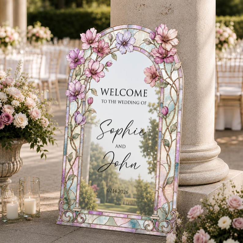 May include: An arched wedding welcome sign featuring a stained glass border in pastel pink, blue, and purple hues. The frame is decorated with painted pink flowers and vines. The text reads: WELCOME TO THE WEDDING OF Sophie AND John 07.14.2026.