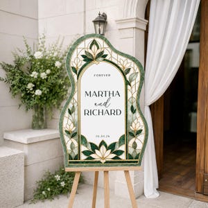May include: An arched wedding sign on a wooden easel featuring a stained glass pattern in shades of dark green and cream. The white center panel displays the text FOREVER, MARTHA and RICHARD, and 10.01.26 in black lettering with a floral motif.
