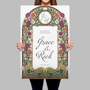 K&ouml;nnte beinhalten: Eine Hochzeits-Willkommensschild mit einem Buntglas-Design. Das Schild zeigt die Namen "Grace & Rick" in eleganter Schrift, umgeben von floralen Elementen in Rosa, Orange und Gr&uuml;n. Das Datum "07.08.26" ist ebenfalls angegeben.