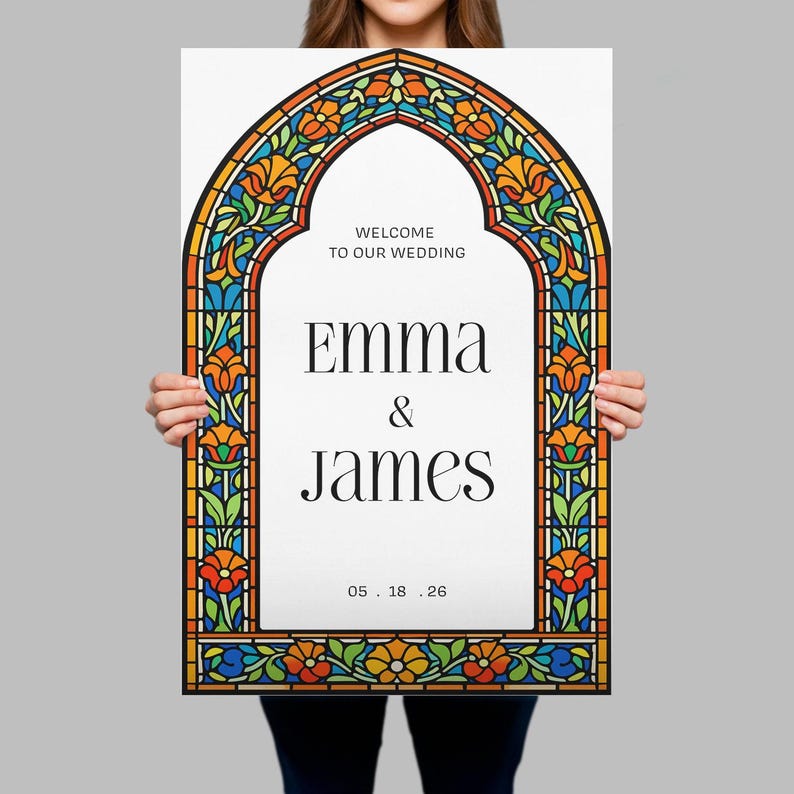 May include: A rectangular wedding sign featuring a white centre with the black text WELCOME TO OUR WEDDING, EMMA & JAMES, and 05.18.26. The sign is framed by a colourful stained glass pattern in orange, blue, and green hues with floral motifs.