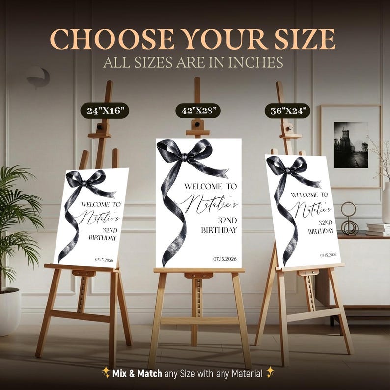 May include: Three white rectangular birthday signs on wooden easels, each featuring a black watercolor ribbon graphic and the text: Welcome to Natalie's 32nd Birthday 07.15.2026. Sizes labeled above are 24x16 inches, 42x28 inches, and 36x24 inches.