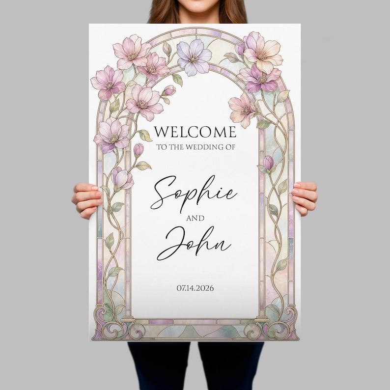May include: A rectangular wedding welcome sign featuring a stained glass archway frame with pastel pink and purple flowers. The text reads: WELCOME TO THE WEDDING OF Sophie AND John 14.07.2026. The design includes intricate glass panel details.