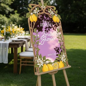 May include: A wooden easel holds a sign with the text "Welcome to Amanda's Bridal Shower" and the date March 25, 2026. The sign features a purple background with lemon and floral illustrations. The easel is set up outdoors.