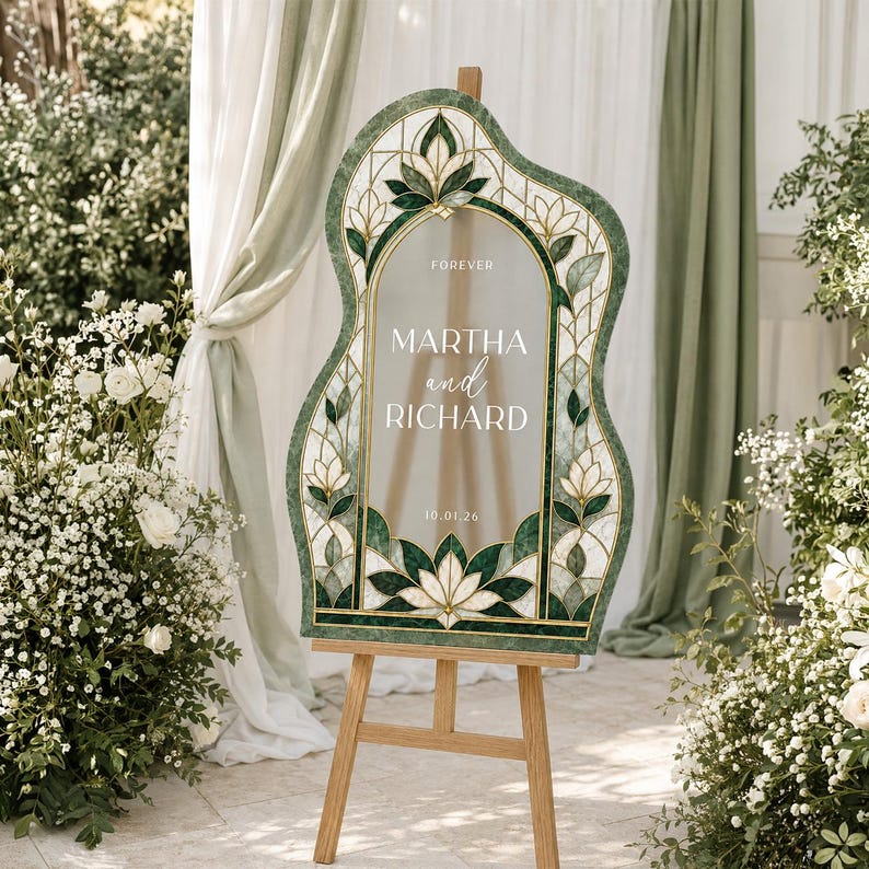 May include: An arched, irregular-shaped wedding welcome sign featuring a stained glass-inspired border in shades of dark green and white. The center displays the text: FOREVER, MARTHA and RICHARD, 10.01.26. The sign is mounted on a wooden easel.