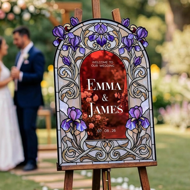 May include: An arched wedding welcome sign featuring a stained glass-style border with purple iris flowers and gold scrollwork. The center is a deep red panel with white text reading: WELCOME TO OUR WEDDING, EMMA & JAMES, 07.08.26.