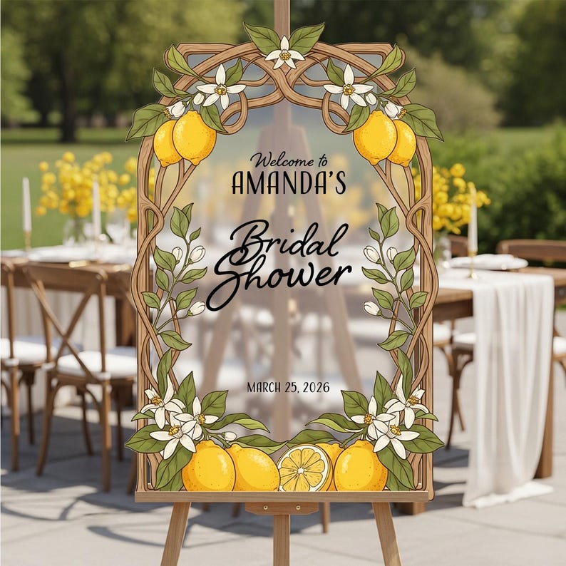 May include: A wooden easel displays a sign for Amanda's Bridal Shower, framed with lemons, white flowers, and green leaves. The sign reads "Welcome to Amanda's Bridal Shower" and "March 25, 2026".