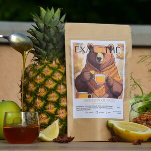 May include: A brown paper bag with a cartoon bear holding a cup of tea. The bag is labeled "Exal Thé" and "Infusion Ourson Saveurs Miel-Citrus". The ingredients are listed as: Pomme, Fenouil, Anis, Baies de Sureau, Fleurs de Souci, Arôme Naturel. Ingredients issus de l'agriculture durable. 10-12 min. D210. LOSS0042.