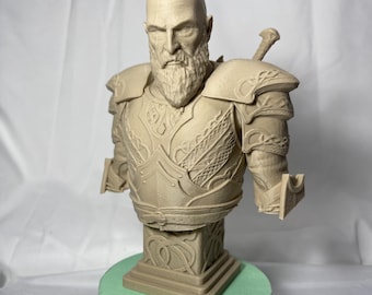 Pode incluir: Um busto de um homem careca com barba, vestindo armadura e segurando uma espada, impresso em 3D. O busto é pintado em cor bege e está sobre uma base verde.