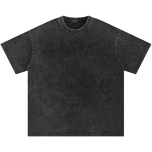May include: A charcoal grey, short-sleeved t-shirt with a crew neck. The shirt has a faded, vintage wash appearance. The fabric appears soft and slightly textured. The overall style is casual and relaxed.