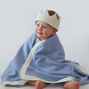 Un joli bébé au chaud dans notre couverture Botiboty bleue  100 % cachemire. elle est fabriquée à partir de fils de cachemire luxueux soigneusement choisi par nos soins