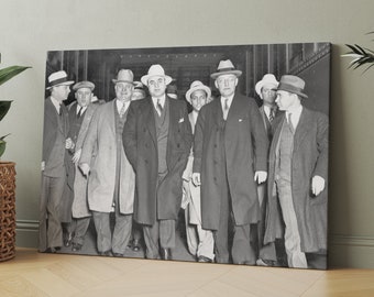 May include: A black and white photograph of a group of men in suits and hats. The men are standing in a line, and they are all looking at the camera. The men are wearing fedoras and suits. The photo is taken in a hallway.