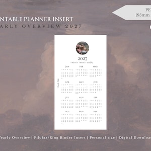 May include: A white printable planner insert for a yearly overview of 2027. The document features a circular photo at the top, the year 2027, and a calendar grid for all twelve months. It is labeled as personal size, measuring 95mm x 171mm.