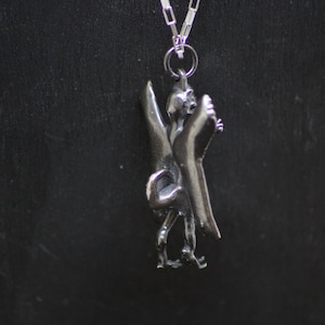 May include: Silver pendant necklace featuring a detailed sculpture of a mythical bird, a symbol of Liverpool, England.