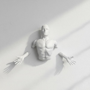 May include: A white wall sculpture of a male torso with outstretched arms and hands. The sculpture is mounted on a white wall, with shadows cast across the surface. The sculpture is a minimalist art piece.