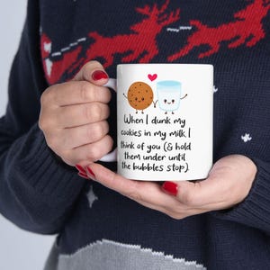 Può includere: Una tazza in ceramica bianca con una simpatica illustrazione di un biscotto e un bicchiere di latte. Il testo sulla tazza recita: "Quando immergo i miei biscotti nel mio latte, penso a te (& li tengo sotto fino a quando le bolle non si fermano)."