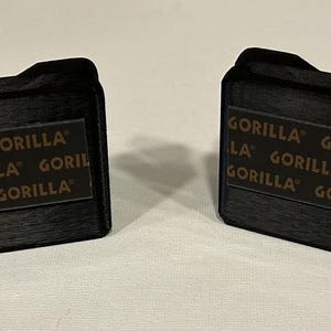 May include: Two black rectangular boxes with the text "GORILLA" printed on them in brown letters.