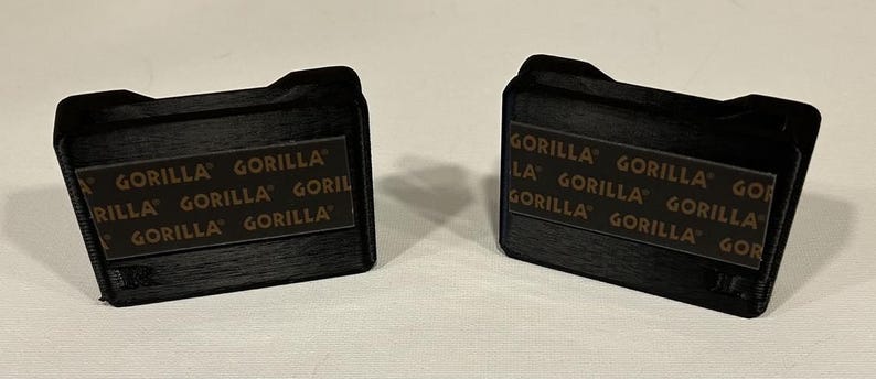 May include: Two black rectangular boxes with the text "GORILLA" printed on them in brown letters.