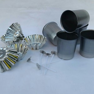 May include: A set of candle making supplies including five silver metal candle containers, four silver metal candle molds, and five white candle wicks.