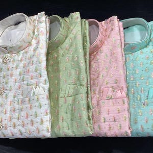 Pode incluir: Quatro camisas com padr&otilde;es diferentes, com colarinho mandarim e um bolso no lado esquerdo. As camisas s&atilde;o de cor branca, verde, rosa e azul.