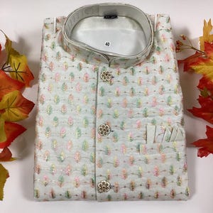 Pode incluir: Uma camisa branca de bot&otilde;es com colarinho mandarim e padr&atilde;o floral. A camisa tem tr&ecirc;s bot&otilde;es dourados e um bolso do lado direito. O tamanho 40 est&aacute; impresso no interior do colarinho.