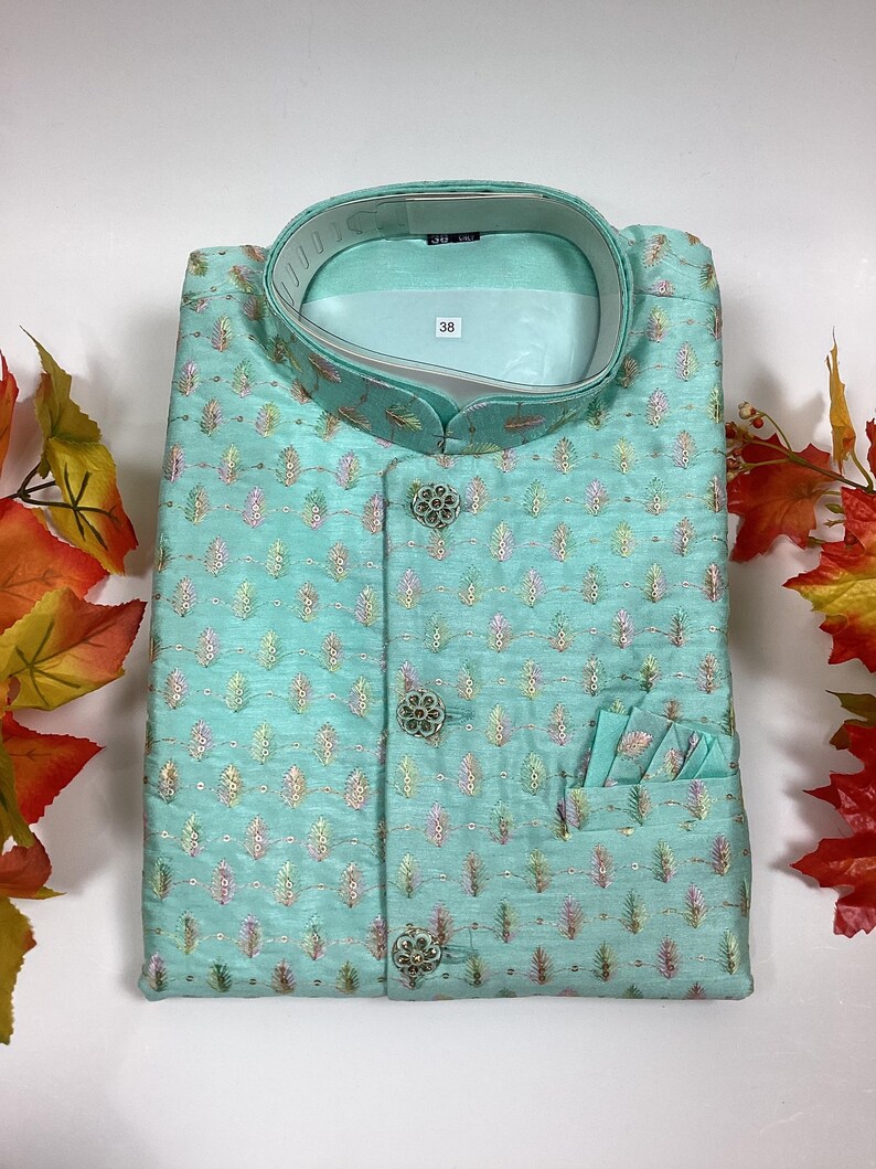 Pode incluir: Uma camisa azul claro estampada com colarinho mandarim e tr&ecirc;s bot&otilde;es. A camisa tem um bolso do lado direito e uma etiqueta de tamanho que diz "38".