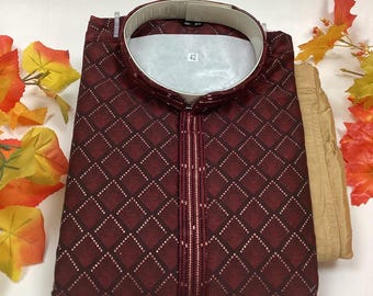 May include: A maroon kurta with a geometric pattern and a matching pair of beige pants. The kurta has a mandarin collar and a button closure. The size tag says "42".