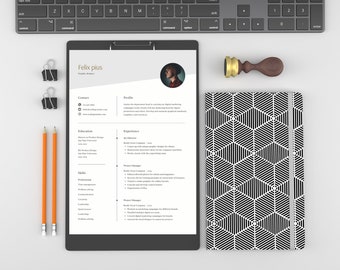 Puede incluir: Una configuración de espacio de trabajo profesional con un currículum vitae, lápices y un cuaderno. El currículum vitae está en un portapapeles, con el nombre "Felix Pius" visible. También hay un cuaderno estampado y un teclado, junto con un sello de madera.