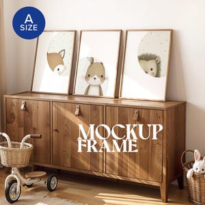 May include: Three framed animal art prints featuring a horse, bunny, and hedgehog, displayed on a wooden cabinet. The prints have a neutral colour palette with a light background and are labelled "A SIZE". A tricycle and a basket with a stuffed bunny are in the foreground. The text "MOCKUP FRAME" is visible.