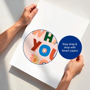 May include: A white poster held by two hands, featuring a colorful circular design with the words "WHAT YOU". A blue circle with white text reads "Easy drag & drop with Smart Layers".