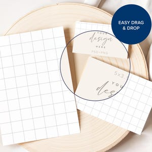 Pode incluir: Dois cart&otilde;es brancos com um padr&atilde;o de grade em uma superf&iacute;cie de madeira. O cart&atilde;o superior tem o texto "Your design here PSD+PNG" e o cart&atilde;o inferior tem o texto "5x3... Your design".