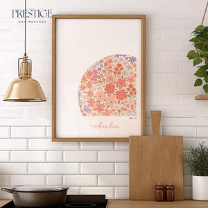 May include: A framed print with a floral design in shades of pink, red, and purple. The print is hanging on a white subway tile wall. There is a wooden cutting board, a potted plant, and a hanging plant in the image.