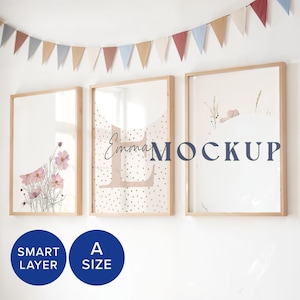 Puede incluir: Tres impresiones enmarcadas con fondo blanco y marcos de madera. La impresión de la izquierda presenta un diseño floral con flores rosas. La impresión del medio tiene un fondo rosa claro con lunares blancos y la palabra "Emma" en una fuente rosa claro. La impresión de la derecha tiene un fondo rosa claro con un diseño floral y la palabra "MOCKUP" en una fuente azul oscuro.