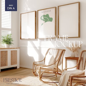 Op de afbeelding: Drie ingelijste kunstprints op een witte muur in een woonkamer. De prints zijn in houten frames. De print links is leeg. De print in het midden heeft het woord "MATISSE" bovenaan en een groen abstract ontwerp. De print rechts is leeg. De tekst "FRAME MOCKUP" is over de afbeelding gelegd.