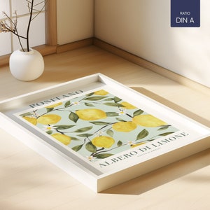 May include: A white framed print with a watercolor illustration of a lemon tree with the text "POSITANO ALBERO DI LIMONE COSTA D'AMALFI" on a light blue background.