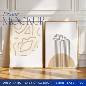 May include: Two framed abstract art prints with gold frames. The print on the left features a beige background with abstract shapes in black and white. The print on the right features a beige background with a black and white geometric design.