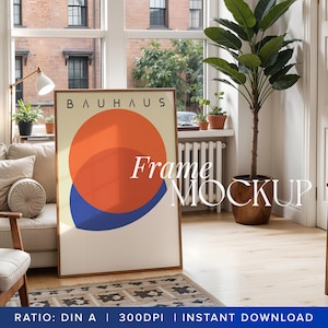 May include: A framed poster mockup featuring a geometric design in red, blue, and white. The poster has the text "Bauhaus" at the top and "Frame Mockup" at the bottom. The poster is placed on a wooden floor in a room with a sofa, a plant, and a lamp.