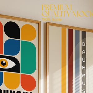 May include: Two framed prints hanging on a wall. The print on the left features a colorful abstract design with a large eye in the center. The print on the right features a vertical striped design with the word "BAUHAUS" in white letters.