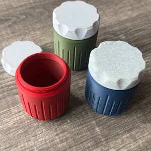 May include: Three small containers with lids. The containers are red, green, and blue. The lids are white with a speckled pattern.